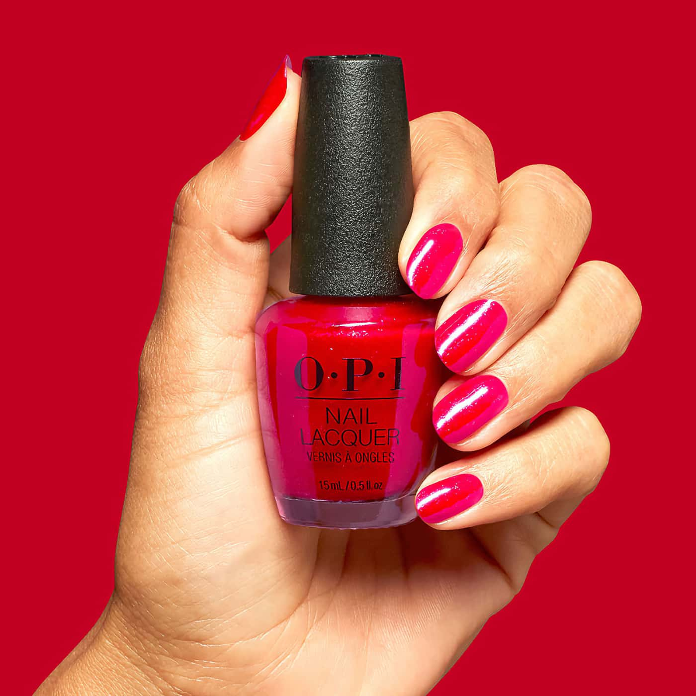 opi opicons big apple energy nagellack i klar körsbärsröd nyans med rosa skimmer